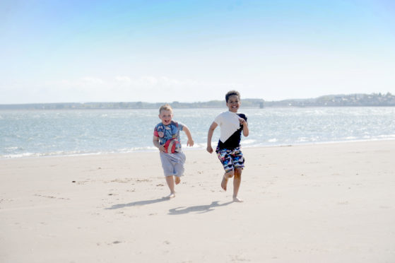 Reilly Fraser and Morris Muzividzi enjoying the sun at Broughty Beach in May 2017.