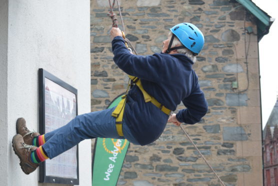 Eighty-year-old Margaret Jarvis abseils down The Birks Cinema.