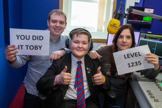 Toby Etheridge celebrates being in remission from his cancer with a visit to his friends at Kingdom FM today, including breakfast presenters Dave Connor and Vanessa Motion.
