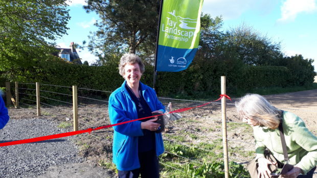 Mahri cutting the ribbon to the new walkway.