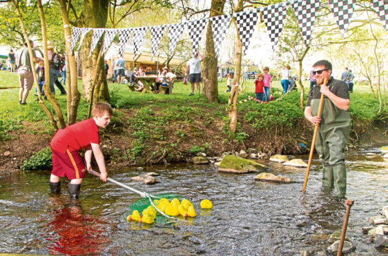 Five year old volunteer Brandon Davidson helping collect the ducks at the finishing line supervised by community outreach ranger Ross Hughes