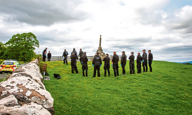 Police search alongside Maggie's Wall Memorial during the investigation.