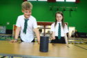 David Bachanek, P4, and Caitlin Walsh, P6, with the 'Alexa' which enables them to find out what is on the school dinners menu, at Rowantree Primary School.