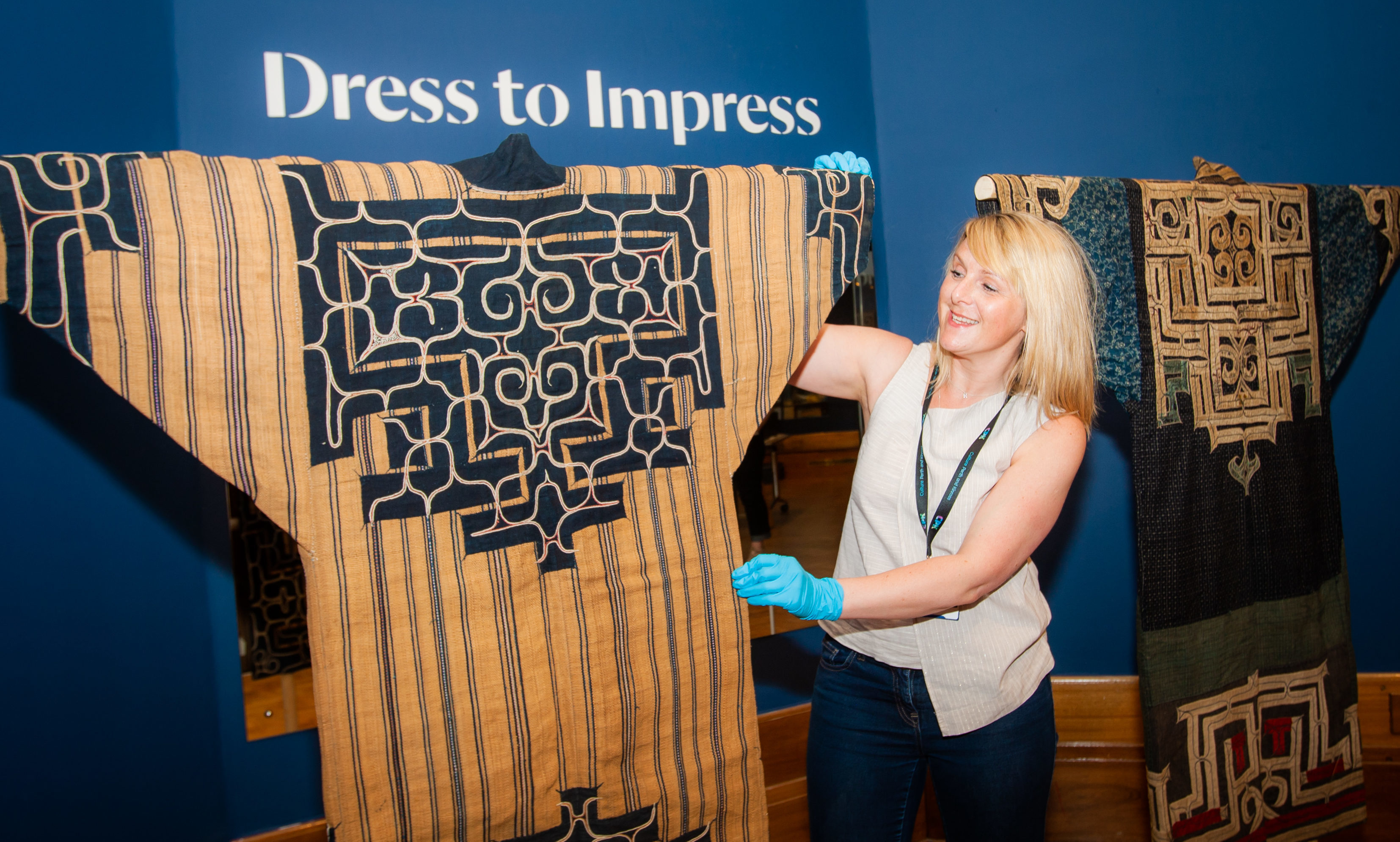 Rhona Rodger (Senior Officer, Collection Management, Culture Perth and Kinross) alongside two Japanese Ainu robes (woven elm tree bark).