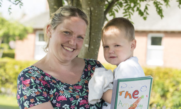 Jackson Scott with mum Jenni and the book