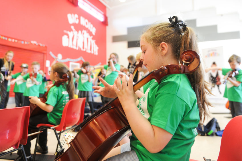 large group of youngsters playing musical instruments.