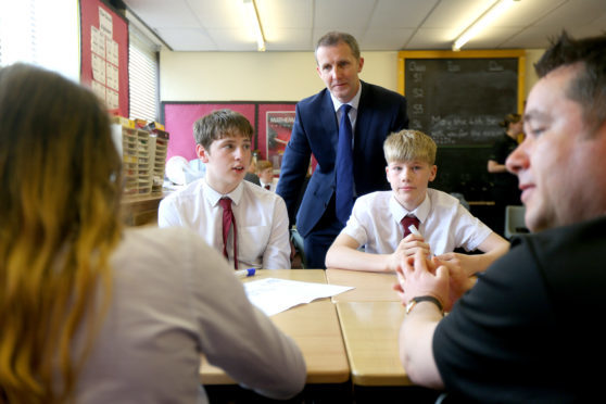 Justice Secretary Michael Matheson with Police Scotland youth volunteers and pupils, Bradley Williamson and Rory Hunter.