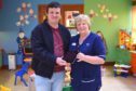 Menzieshill resident Arthur Hayburn donates an iPad to senior charge nurse Catherine Borland