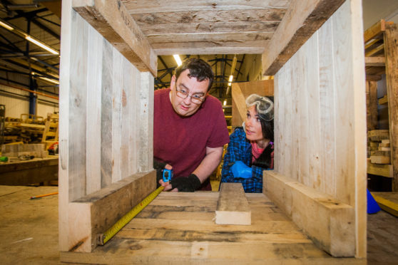 Gayle watches as trainee Peter measures a box he's making at Dundee and Angus Wood Recycling Centre