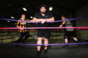 David Low, head trainer for SWE, with trainee wrestlers Kerr Davie and Brandon Tierney.