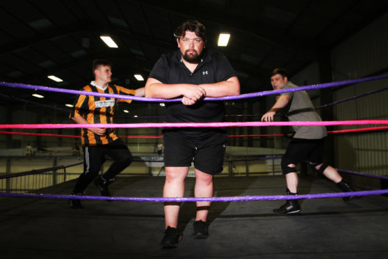 David Low, head trainer for SWE, with trainee wrestlers Kerr Davie and Brandon Tierney.