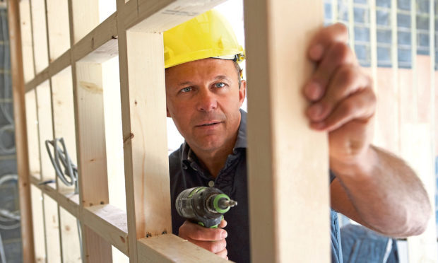A construction contractor builds up a timber partition