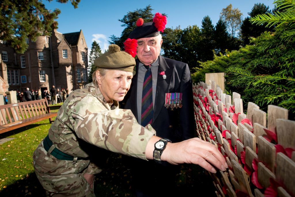 Major (retired) Ronnie Proctor watches as 2LT Sharon Swash (Black Watch AFC - Perth Viewlands) places a cross on the wall to mark the 100th anniversary of the Battle of Loos