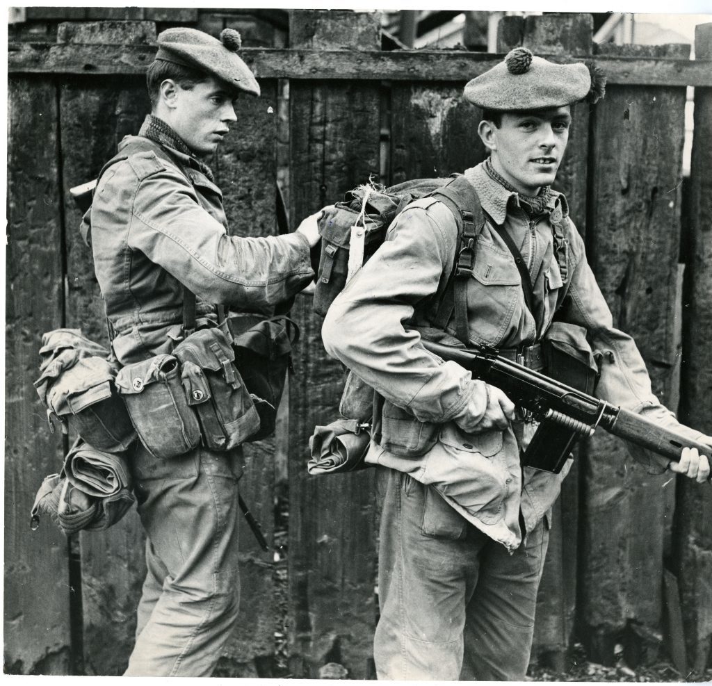 Black Watch at Ulster. Photograph showing R. Rushford, from Cowdenbeath, lending T. Grant, from Dundee, a hand with his kit as the Black Watch are sent to Ulster. June 30 1970. 