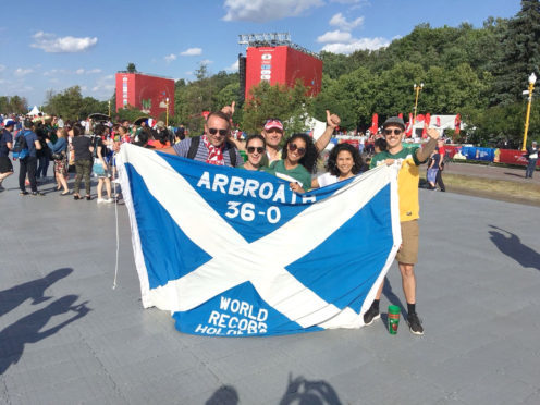 Mr Lorkowski (left) with Australia fans and the flag.