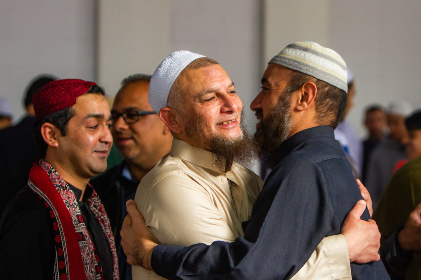 Muslim men embrace following Eid prayer at Dundee Central Mosque