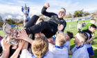 Stewart Petrie held aloft by Montrose players after title win. Image: SNS