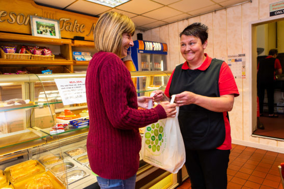 Sandra Reid of Dave's Diner serves local resident Ann Murray with the new compostable carrier bag.