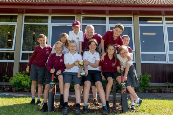 Cricket coach Alan Surtees (centre) with his winning P6 team.