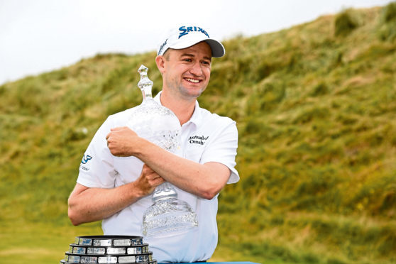 DONEGAL, IRELAND - JULY 08:    Russell Knox of Scotland poses with the trophy following his victory on the 18th green during a playoff at the end of the final round of the Dubai Duty Free Irish Open at Ballyliffin Golf Club on July 8, 2018 in  Donegal, Ireland. (Photo by Ross Kinnaird/Getty Images)