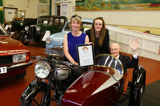 MSP Shona Robison with new chairman John Letford on a  1936 Norton bike with  Samantha Walker.