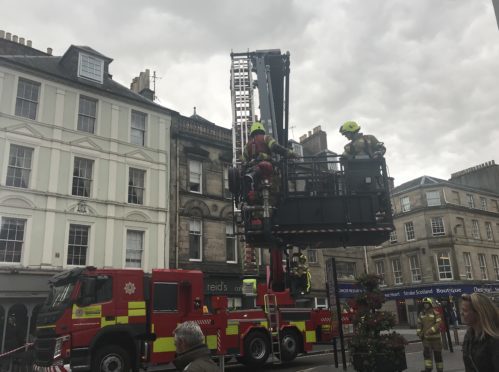 Aerial ladder checking chimney fire above Perth restaurant.