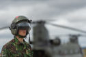 A serviceman stands in front of a Chinook helicopter at Leuchars Station in July 2018.