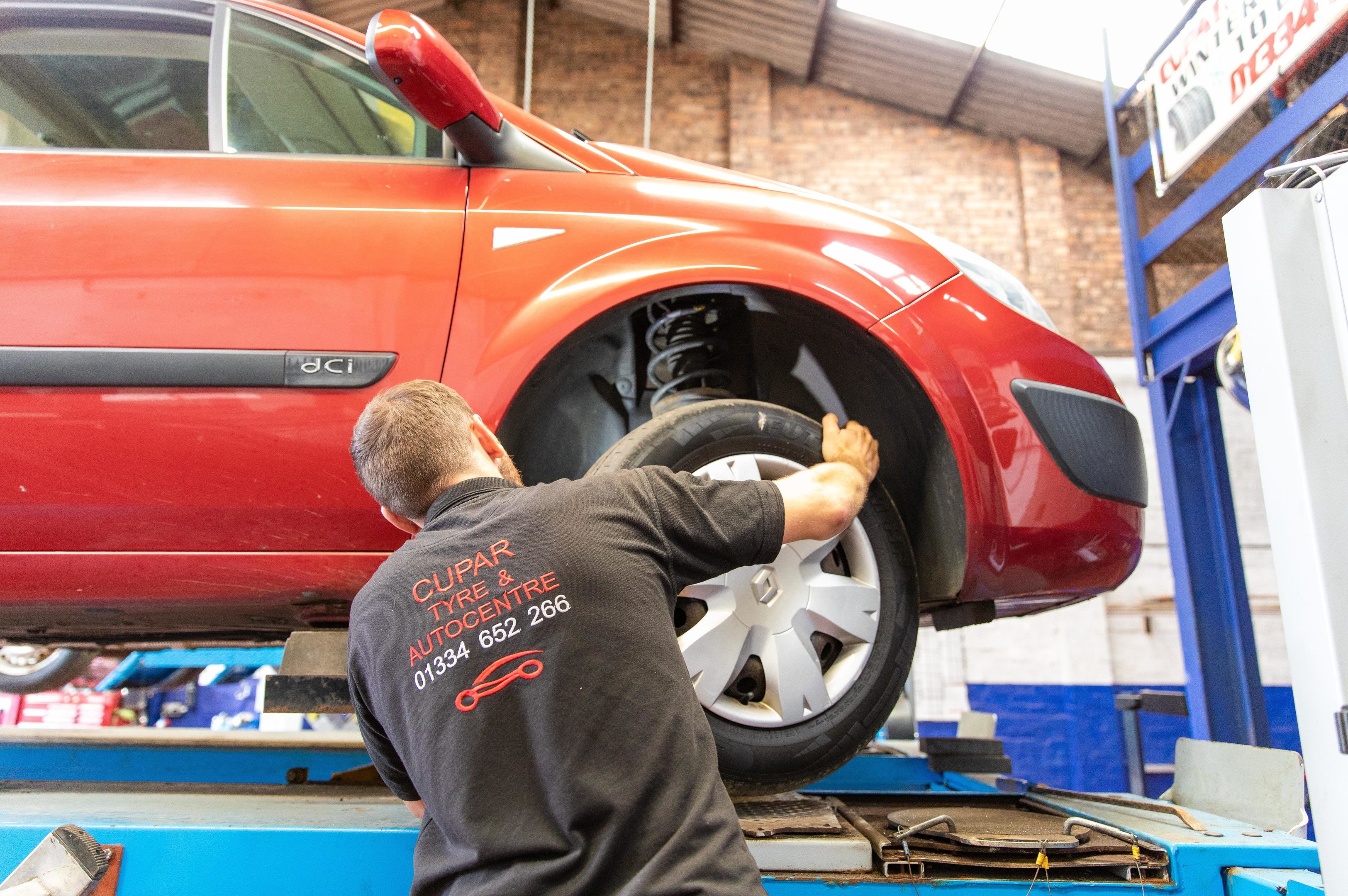 Wheels being examined on the Renault Megane by MOT Tester John Beveridge at Cupar Tyre and Autocentre