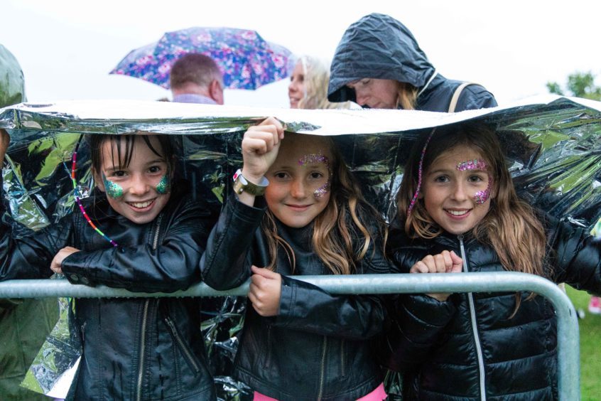 Fans in the rain during a sudden downpour at the Rita Ora gig