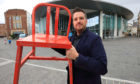 Artist Sean Blake with his red chair, outside Perth Concert Hall.