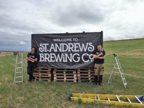 Head brewer Rob Lowe and sales and marketing manager Ben Wallace pose by one of their new billboards.