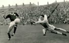 Dundee United goalkeeper Sandy Davie saves from Dundee striker Alan Gilzean during a city derby at Tannadice in September 1962. Also pictured is United right-back Tommy Millar.