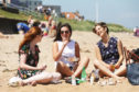 Catherine Mizen, 21, Gillian Anderson, 21 and Eileen Rapport, 21, students from St Andrews enjoying the weather down on the East Sands during the heatwave in 2018.