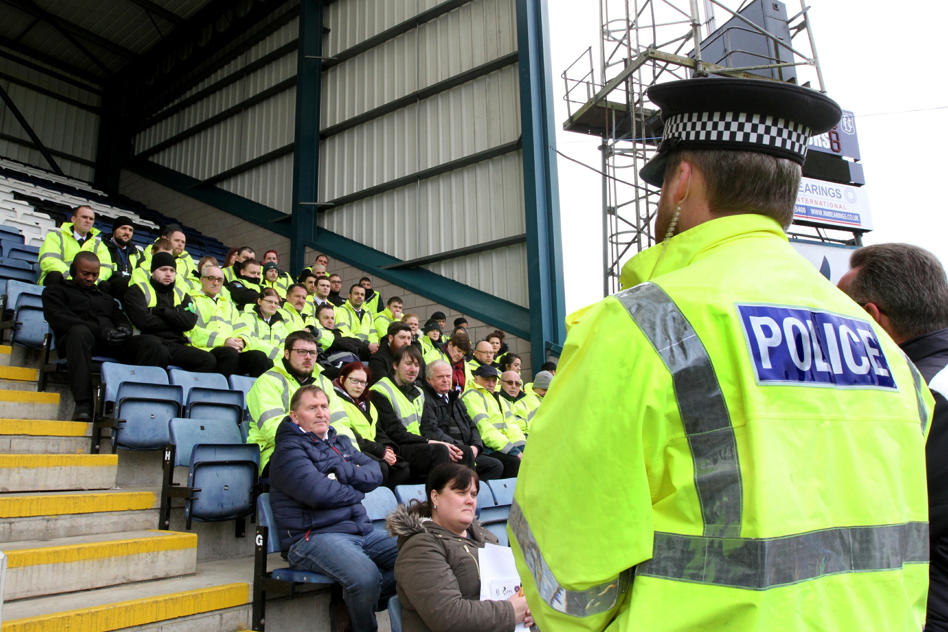 Stewards are briefed by police ahead of a match at Dens Park.