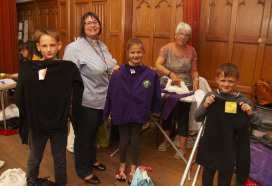 The Rev Maggie Hunt with Ann Menmuir hard at work ironing all the clothes with Alysha Torrie(10) and her brothers Liam(12)(left) and Aidan(12).