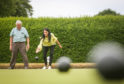 Sam Bryce showing Gayle how to bowl at Orchar Park bowling green.