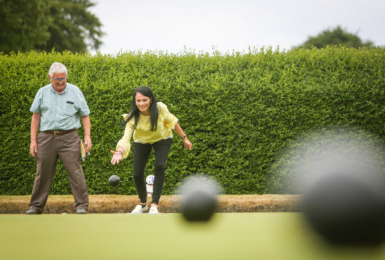 Sam Bryce showing Gayle how to bowl at Orchar Park bowling green.