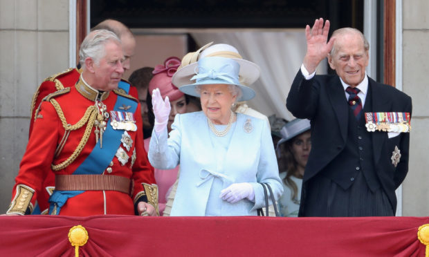 Prince Charles, Queen Elizabeth II and Prince Philip look out from the balcony of Buckingham Palace during the Trooping the Colour parade on June 17, 2017 in London.