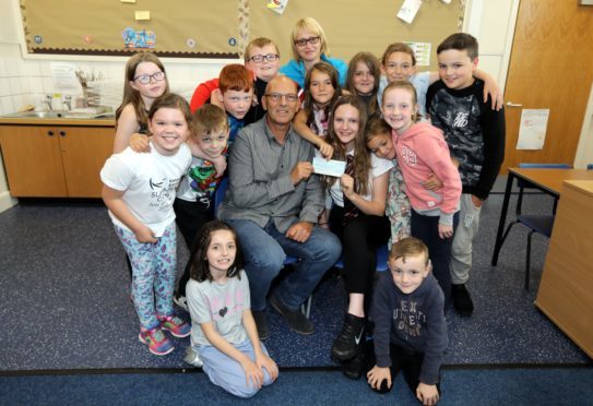 The Cormie family , mum Alison , dad Stuart and 11-year-old Ellie accepted a cheque from the pupils of Aberlemno primary to support the work of the Tayside Deaf Children's Society