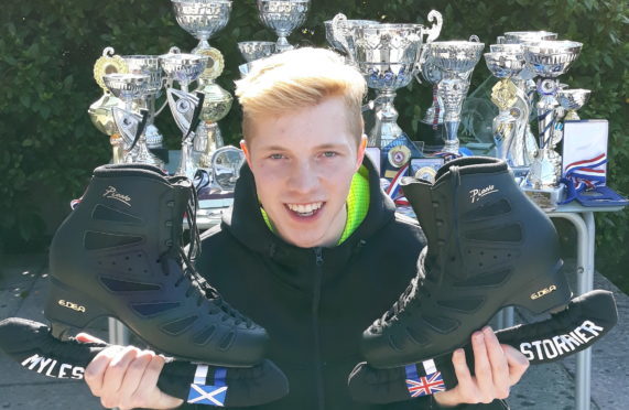 Myles Storrier with his skates and trophies.