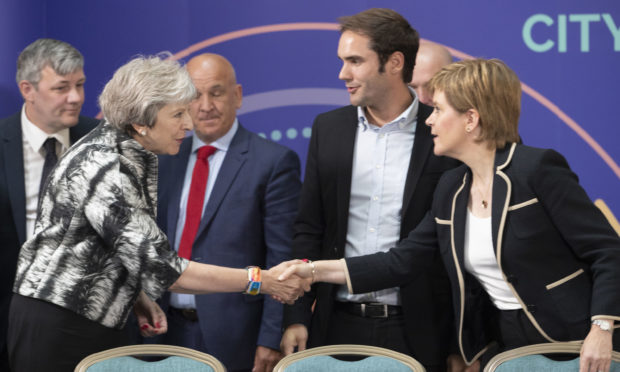 Prime Minister Theresa May and First Minister Nicola Sturgeon shake hands after signing the Edinburgh and South East Scotland City Region Deal at the University of Edinburgh,