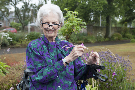 Margaret Smith holding the flower.