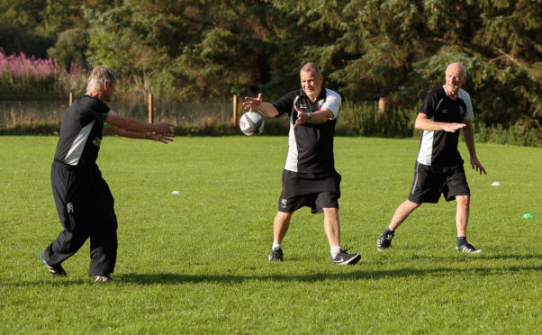Simon Scott, 63, Bob Baldie, 51, and Willie Gray, 62, take part in a pilot walking rugby session at Strathmore