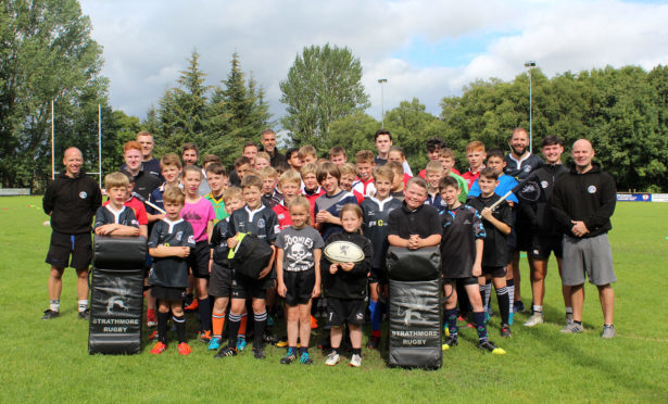 Strathie Sharks members and coaches with the SSEN-funded defibrillator