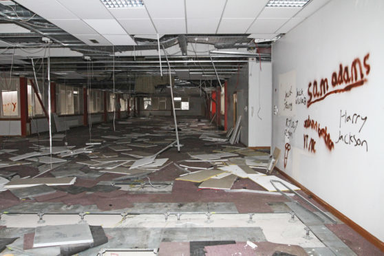 Vandals have torn down the building's ceiling tiles and smashed windows