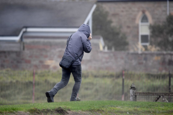 A member of the public struggles in the wind as Storm Ali hits.