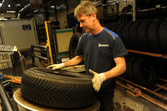 A Michelin Dundee technician carries out an inspection on a tyre.