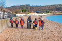 A beach is scoured for rubbish and plastics.