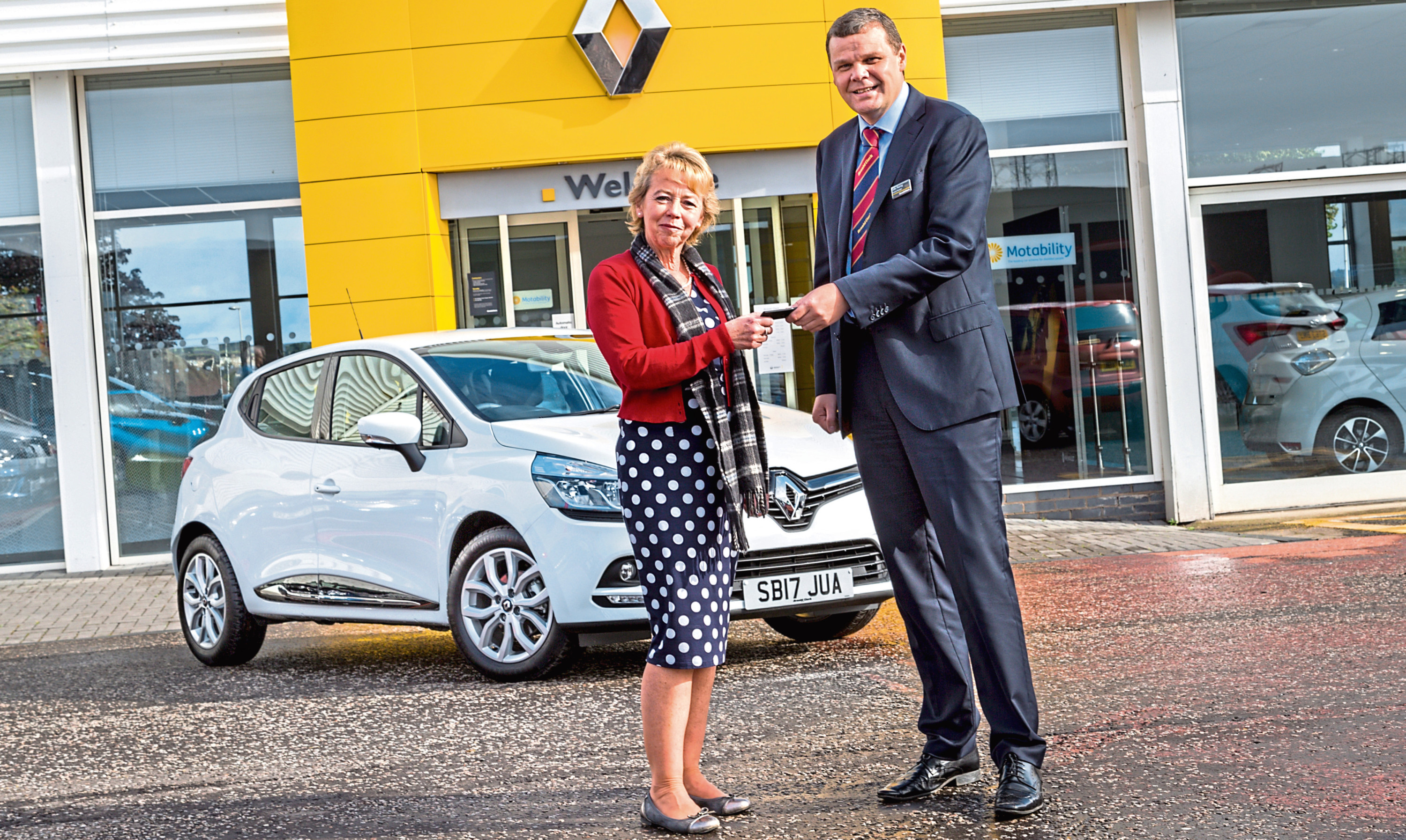 A customer receives the kes to their new car at an Arnold Clark dealership