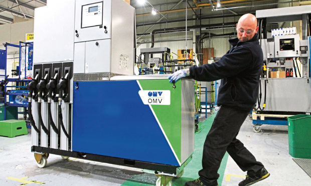 Lucas Krefe, an auditor in the finishing department wheels a Quantium 510 fuel dispenser across the floor of the Dundee factory